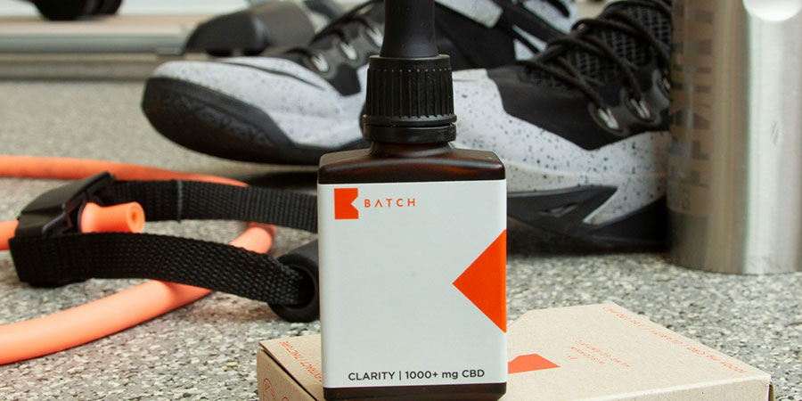 Clarity CBD product, gym equipments and a pair of rubber shoes at the back